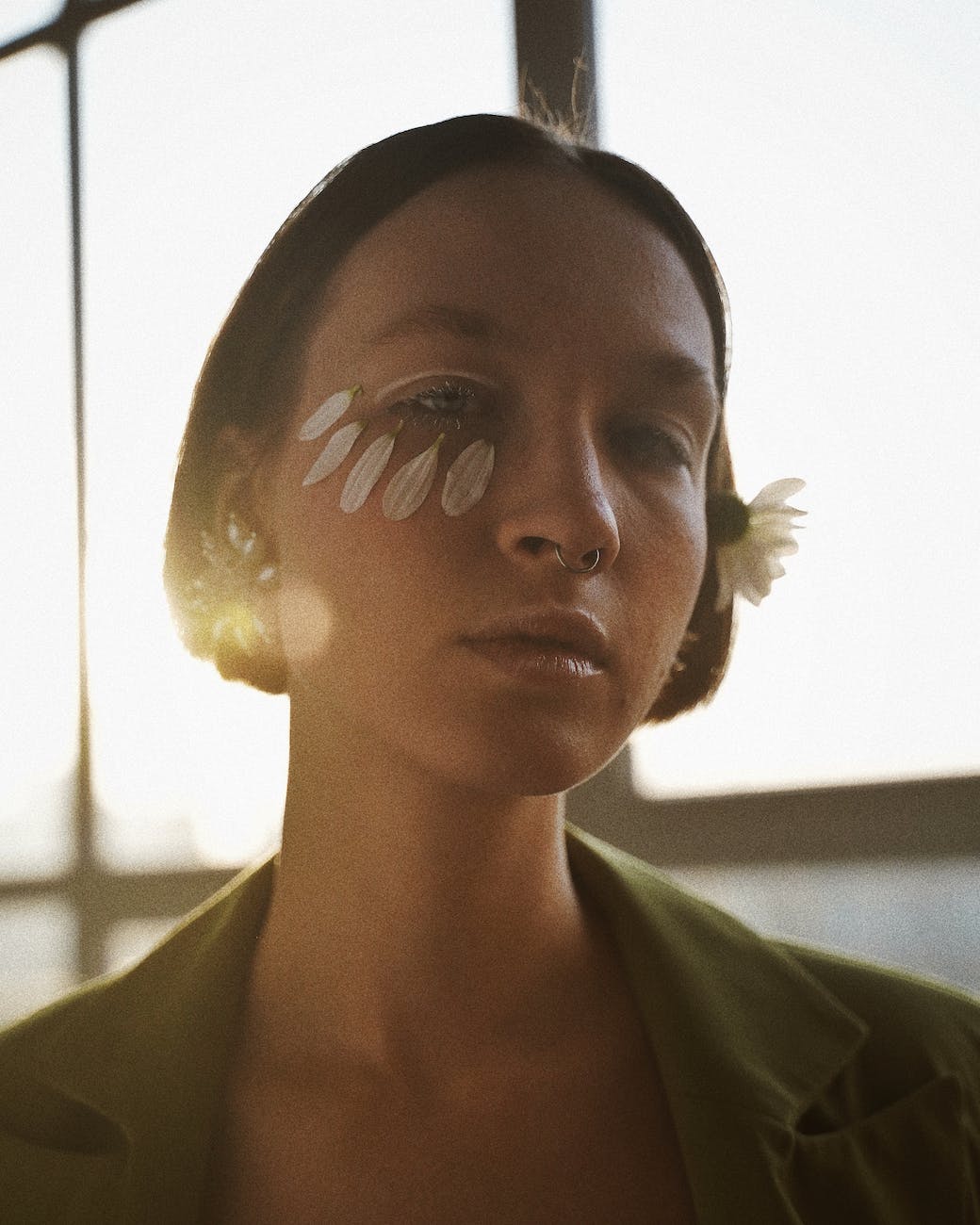 portrait photo of woman with petals on her face